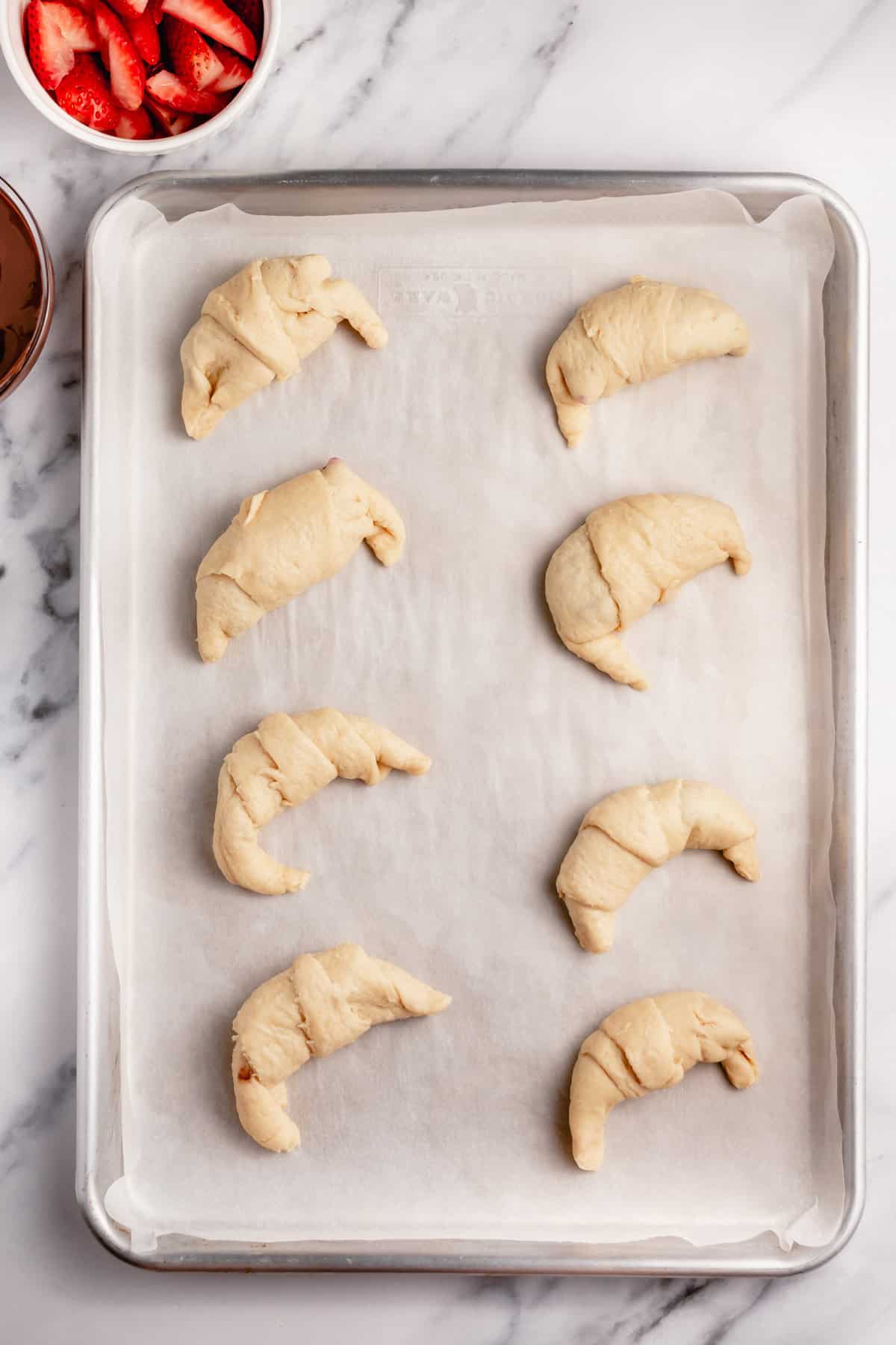 uncooked rolled crescent dough on a baking sheet
