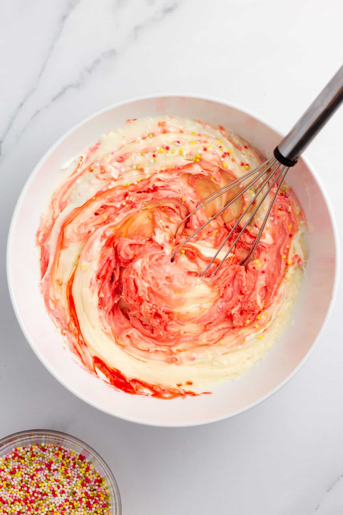 frosting, melted chocolate and food coloring in a mixing bowl