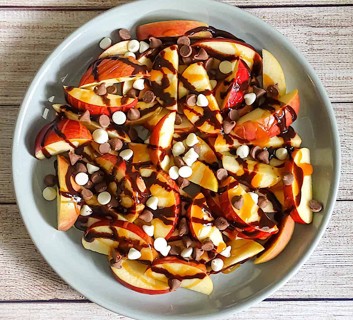 sliced apples drizzled with caramel, chocolate and chocolate chips