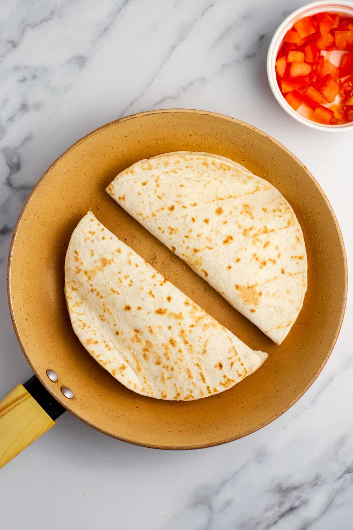 uncooked quesadilla on a frying pan