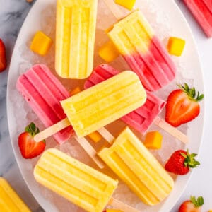 mango popsicles on a white plate