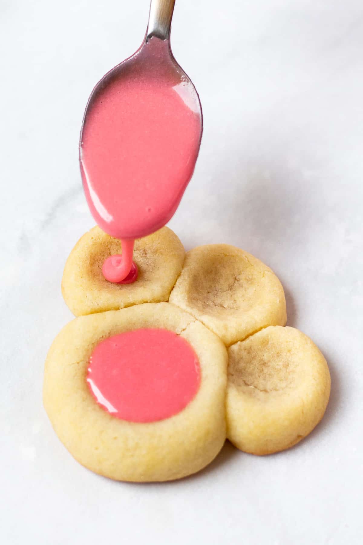 filling holes in cookies with pink icing