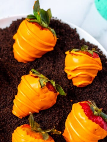 candy coated Easter strawberries on crushed Oreos to resemble a carrot patch