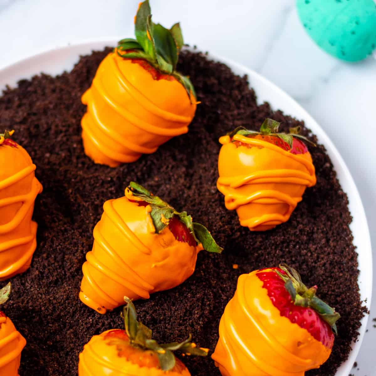 candy coated Easter strawberries on crushed Oreos to resemble a carrot patch