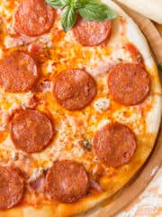 a pepperoni tortilla pizza on a cutting board