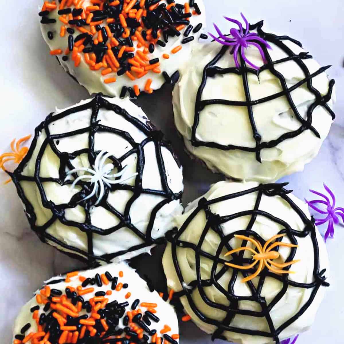 spider donuts decorated with frosting, spider webs and spider rings