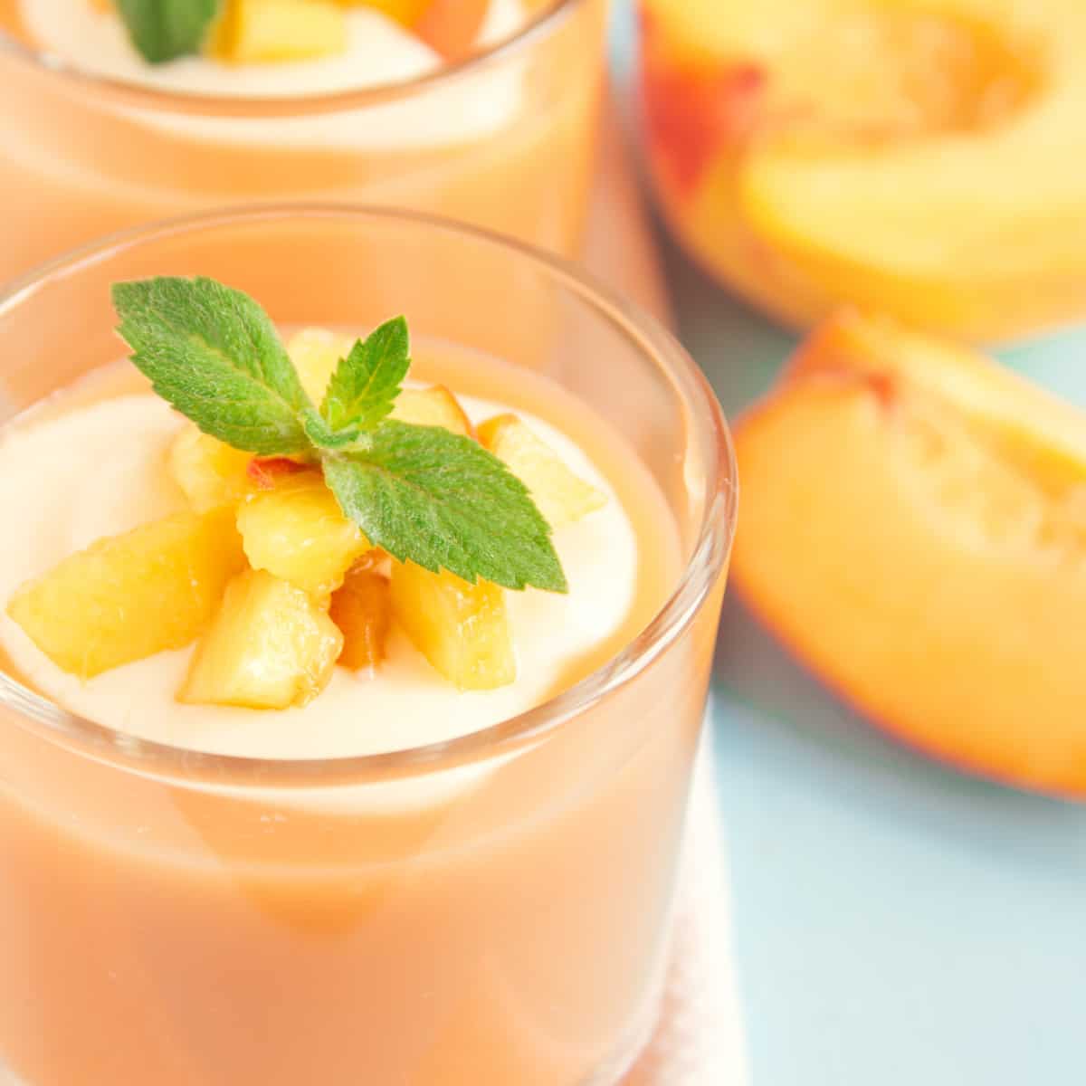 banana peach smoothie in a glass cup garnished with mint