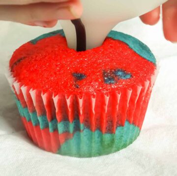 a funnel being inserted into a cupcake