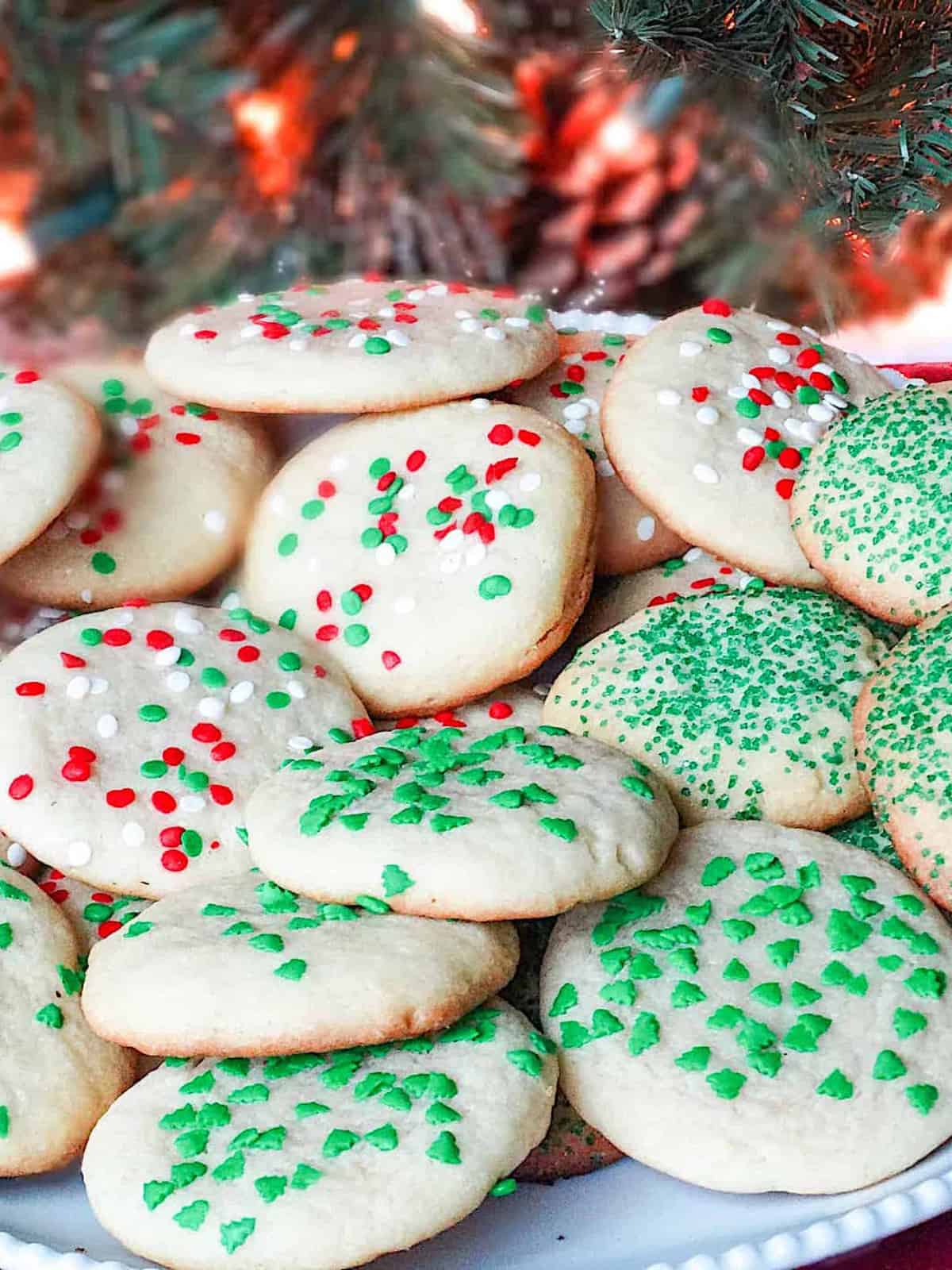 christmas drop sugar cookies on a plate decorated with red and green sprinkles