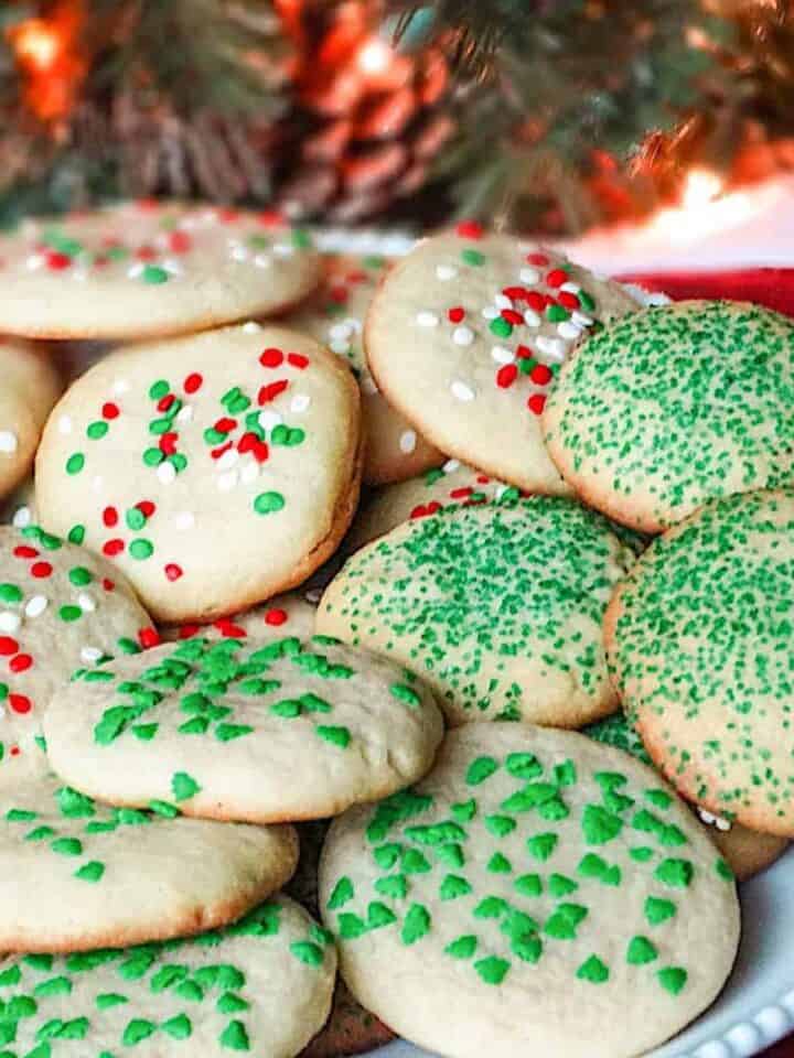 christmas drop sugar cookies on a plate decorated with red and green sprinkles