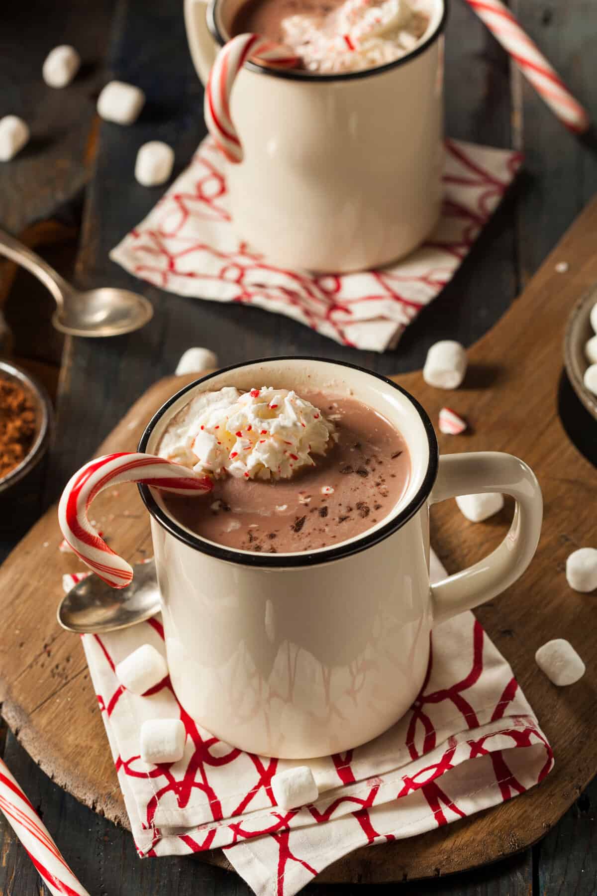 homemade peppermint hot chocolate in 2 mugs topped with whipped cream and crushed candy