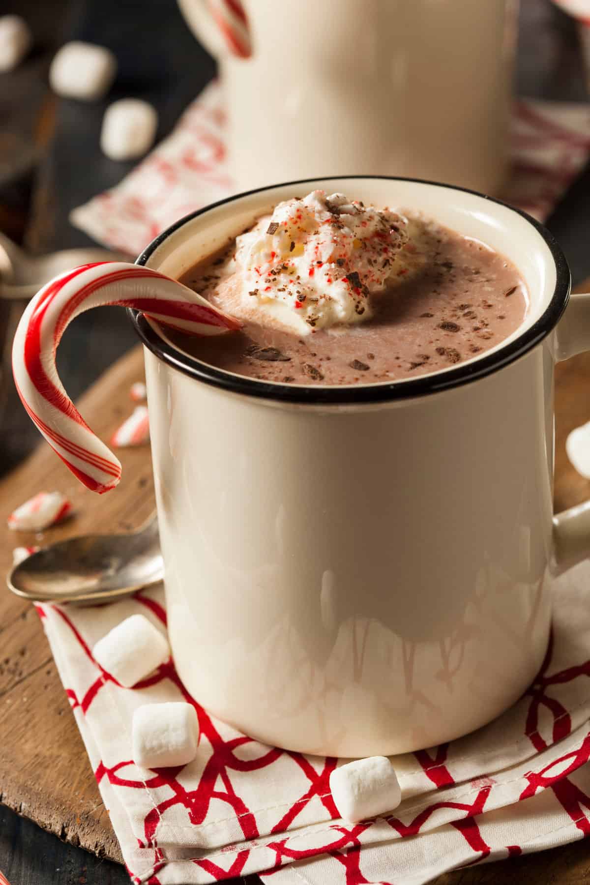 peppermint hot chocolate in a mug topped with whipped cream and candy canes