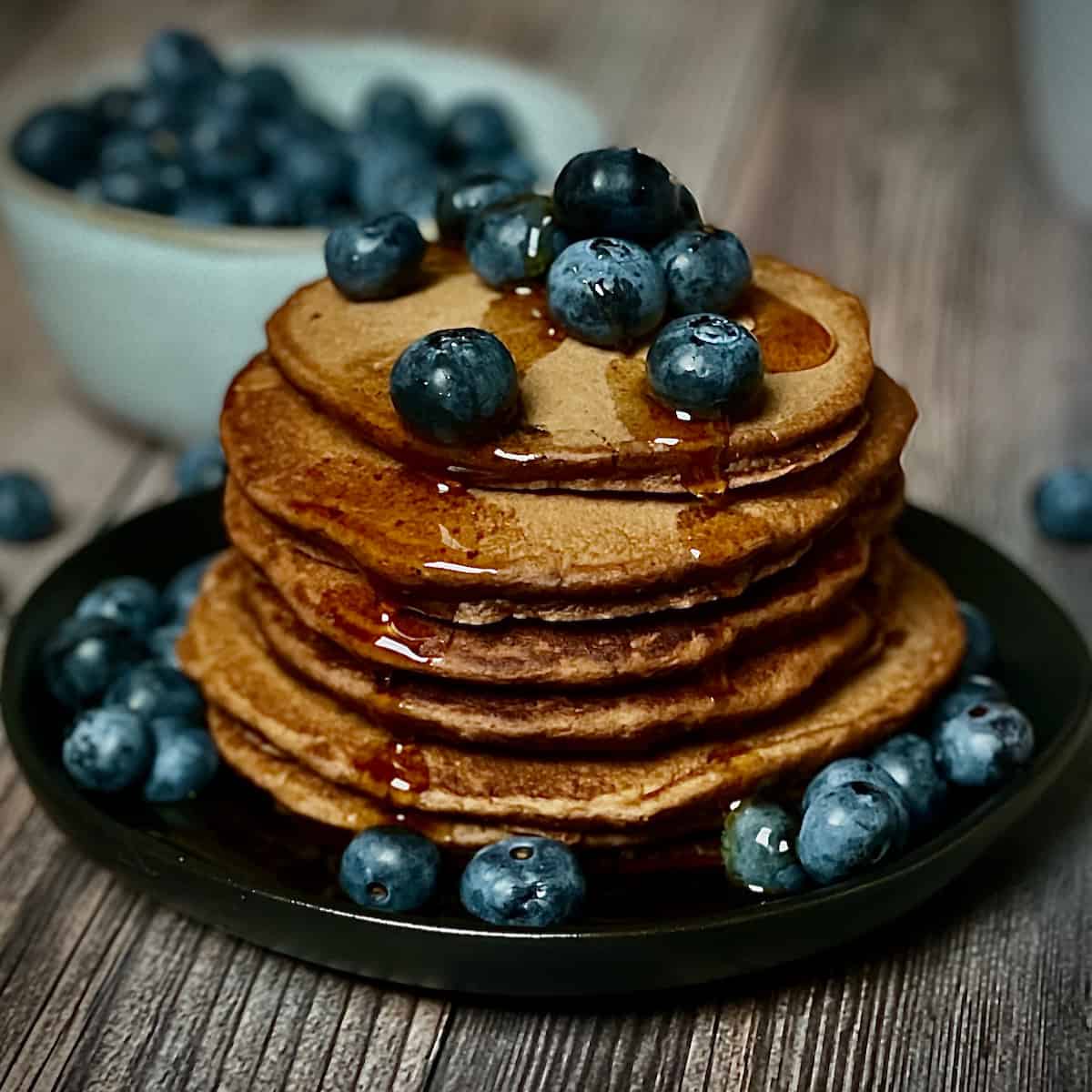 chocolate pancake stack topped with blueberries and syrup