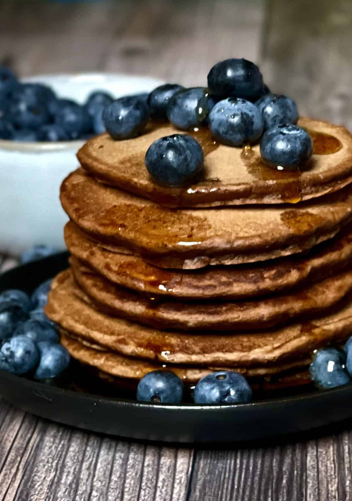 chocolate pancakes stack with blueberries and syrup