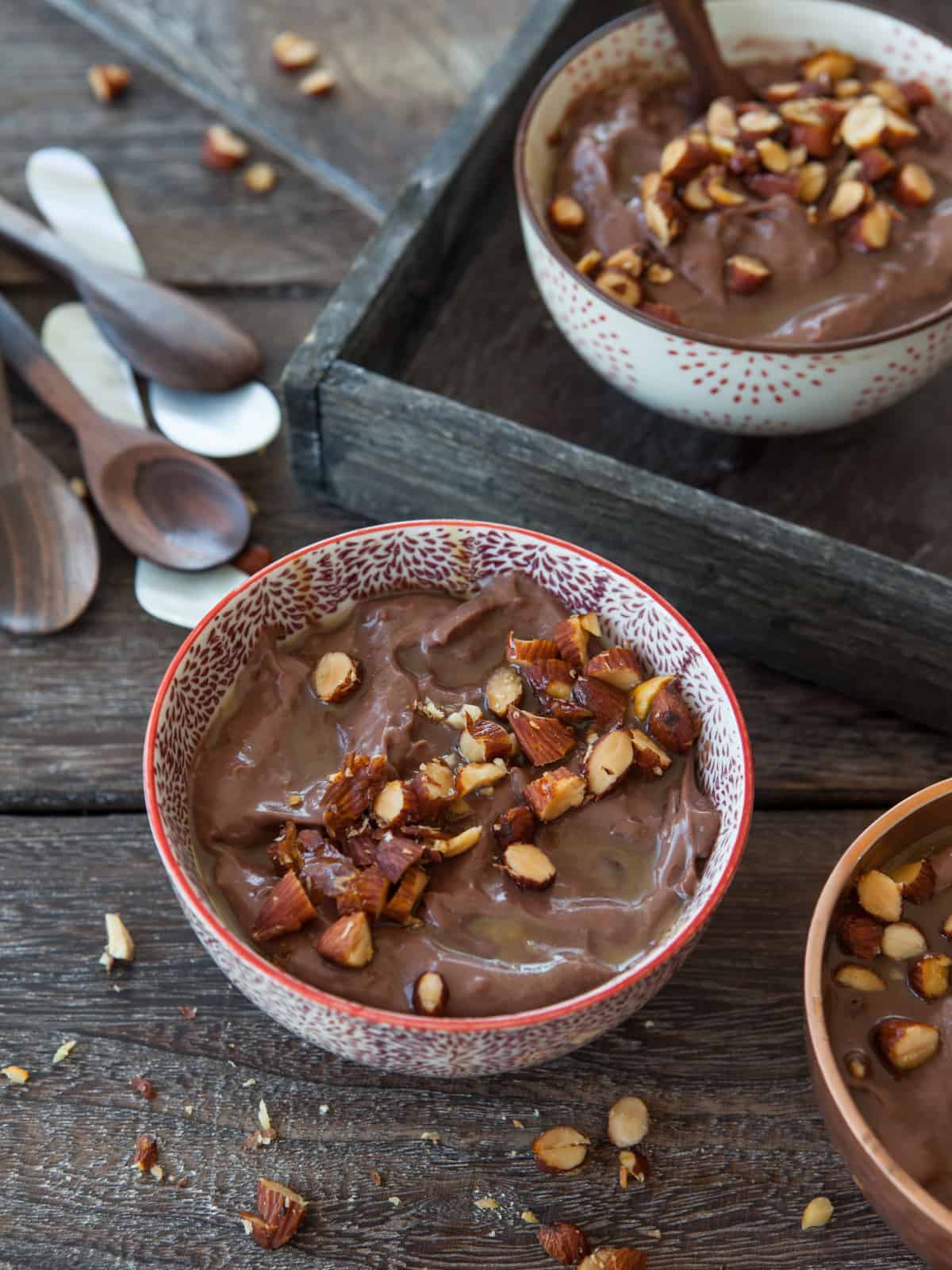 chocolate almond milk pudding in bowls with almonds on top