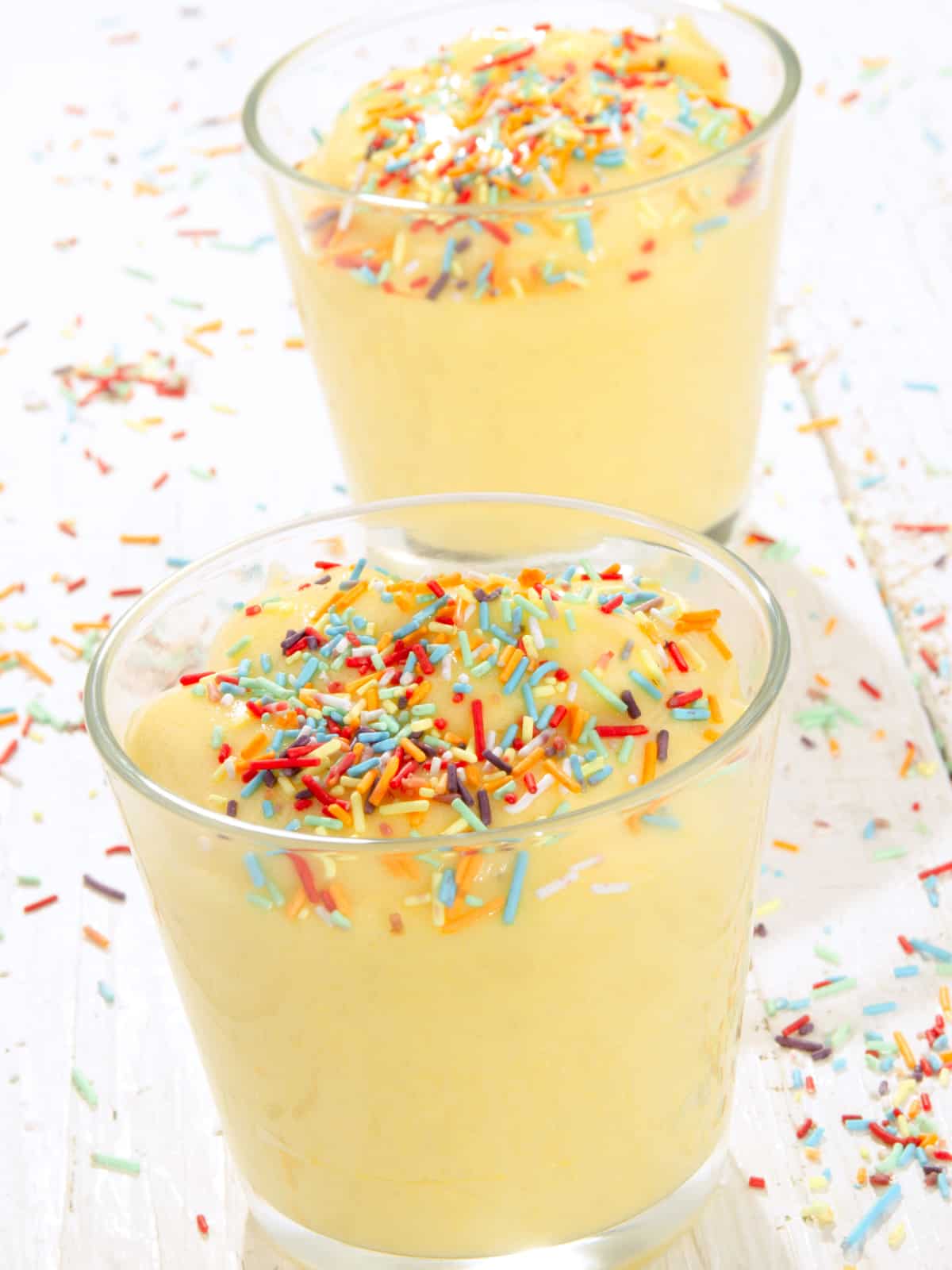 almond milk vanilla pudding in glass cups topped with rainbow sprinkles