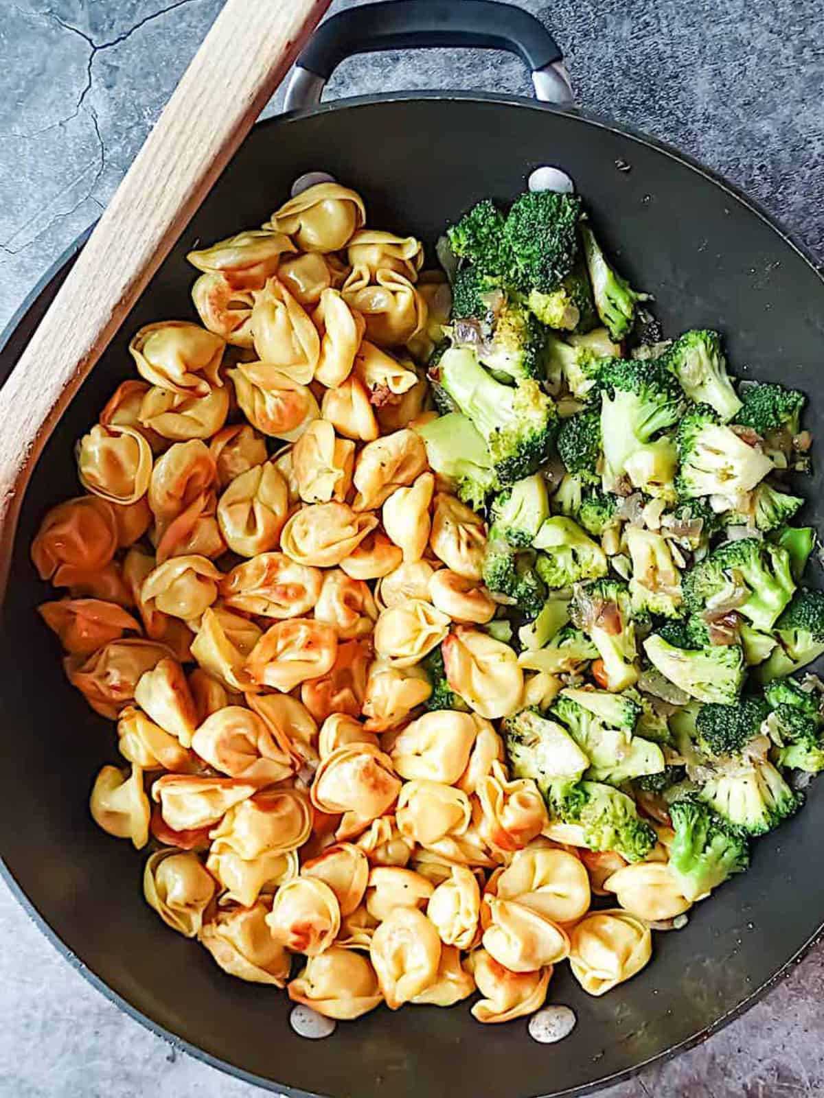 tortellini and broccoli in a large wok