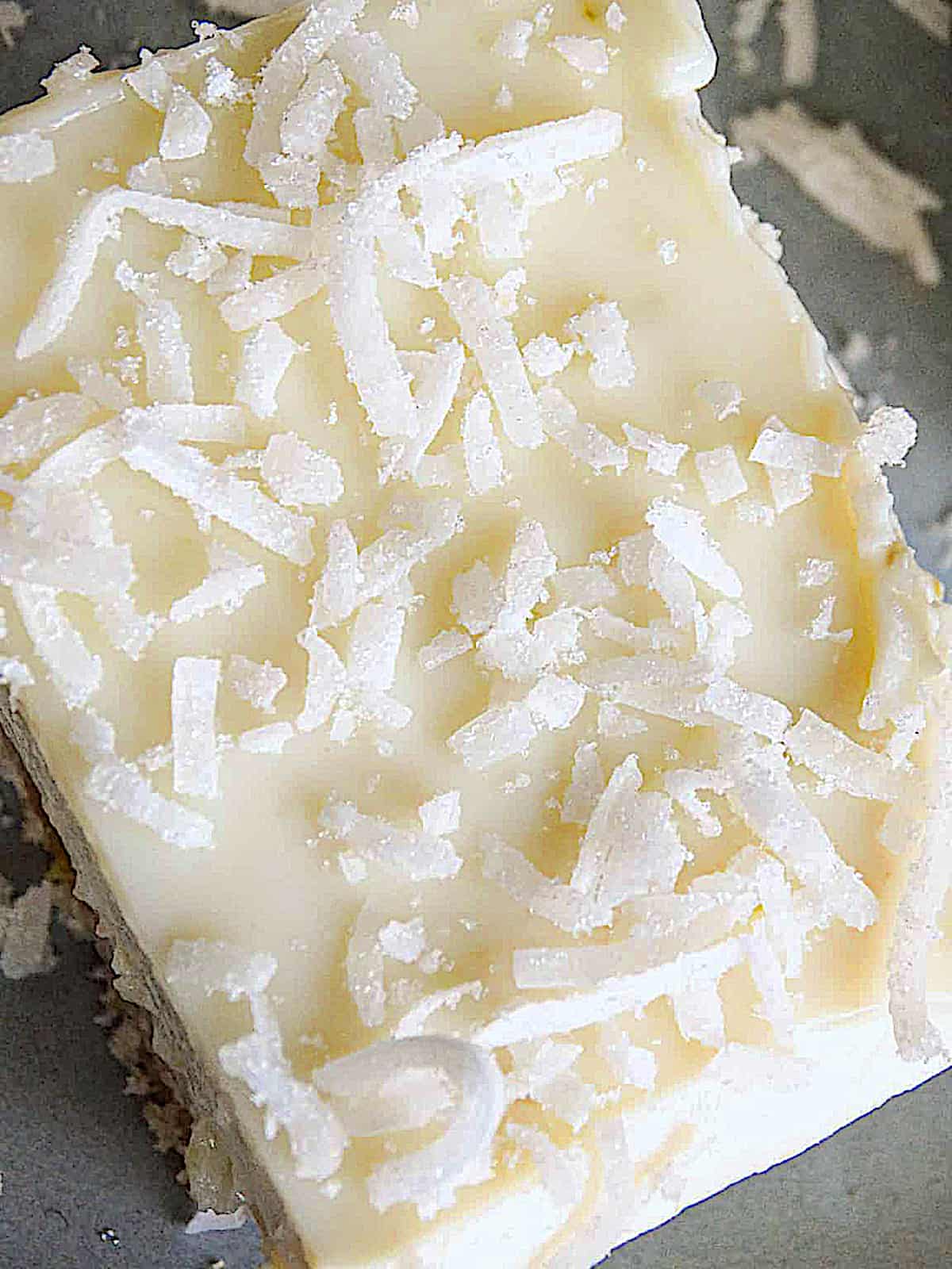 close up of a coconut lime bar topped with shredded coconut