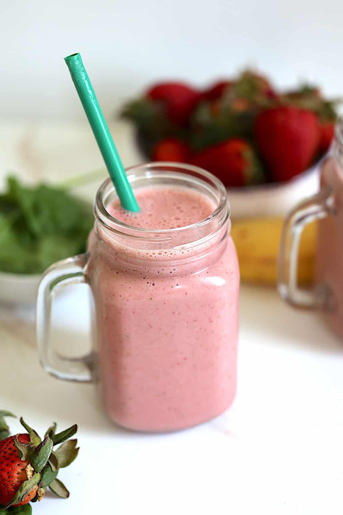 strawberry banana spinach smoothie in a glass mason jar
