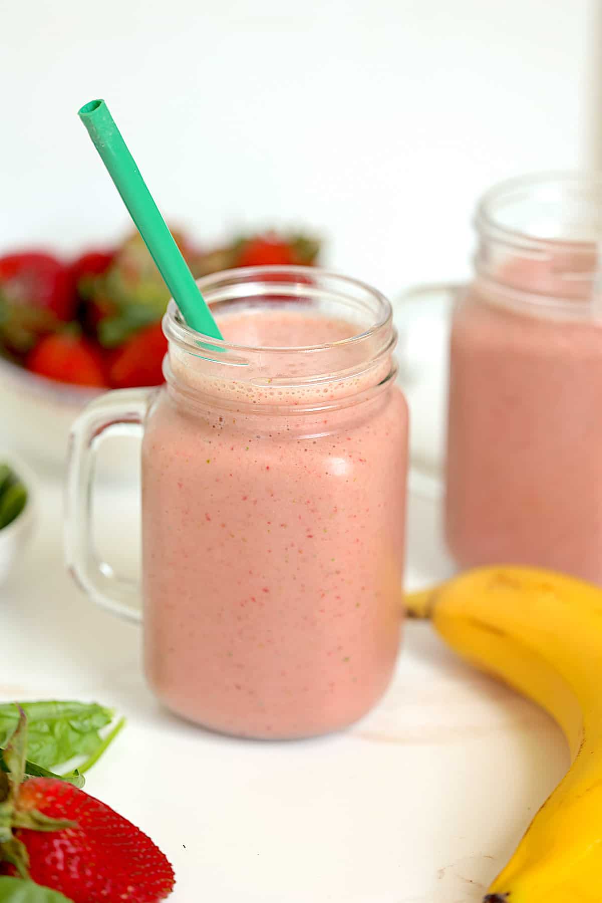strawberry banana spinach smoothie in a mason jar