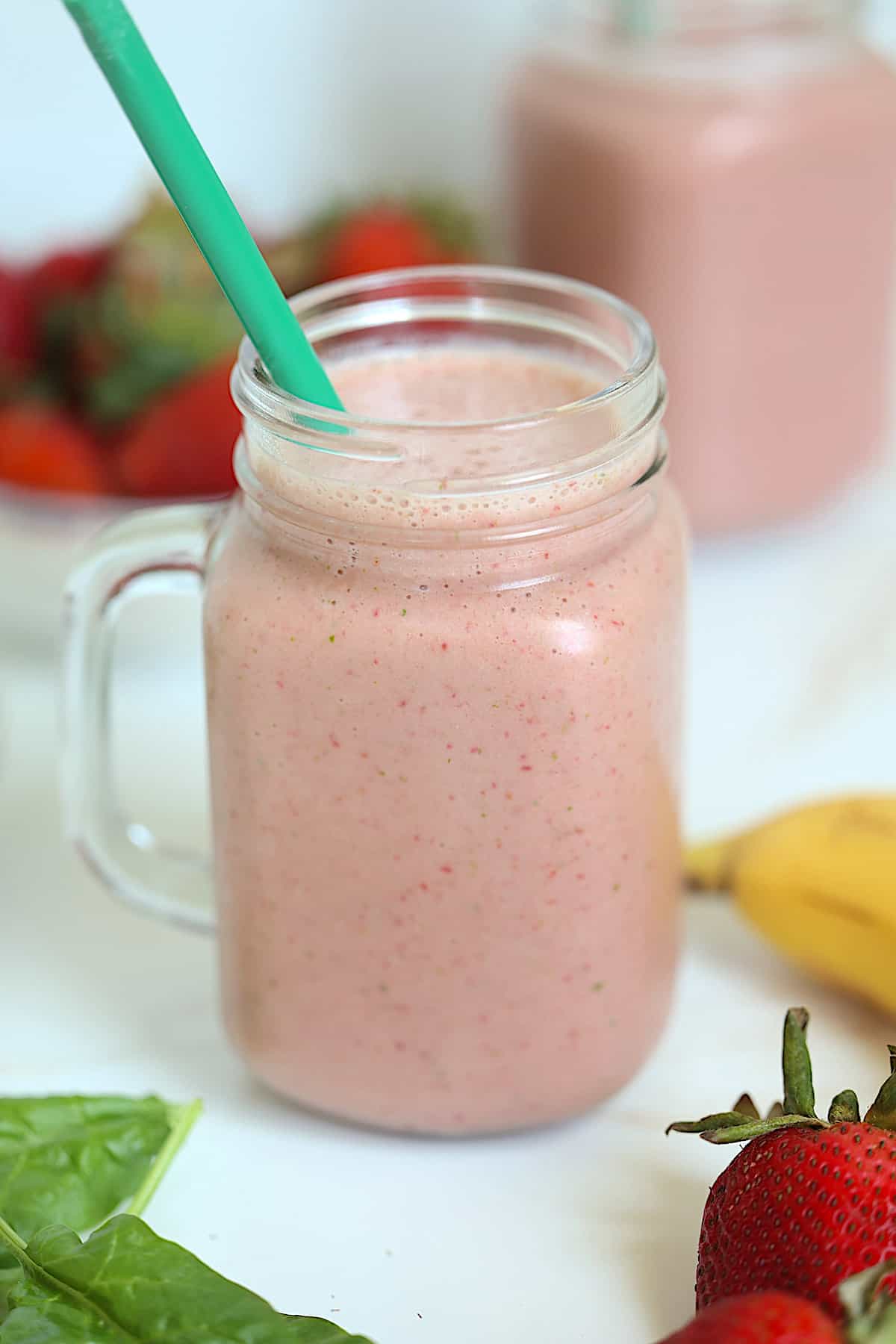 strawberry banana spinach smoothie in a mason glass
