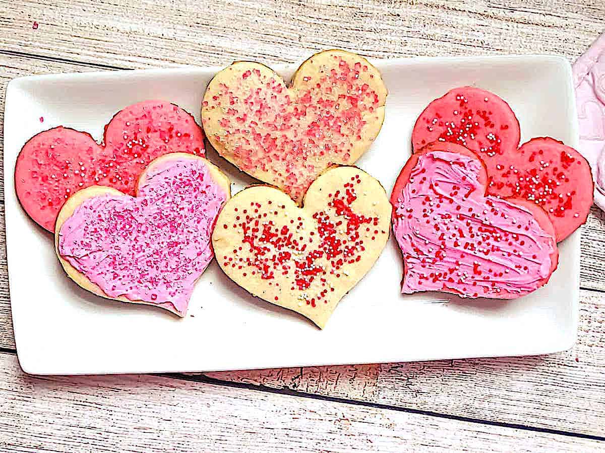heart shaped pink and white cookies on a white plate