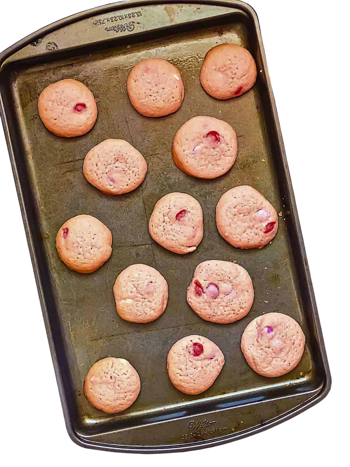 pink sugar cookies on a baking sheet