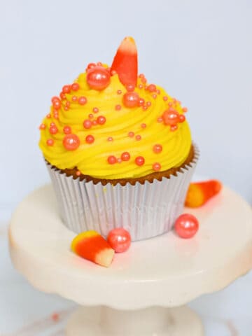 candy corn cupcake on a white cake stand