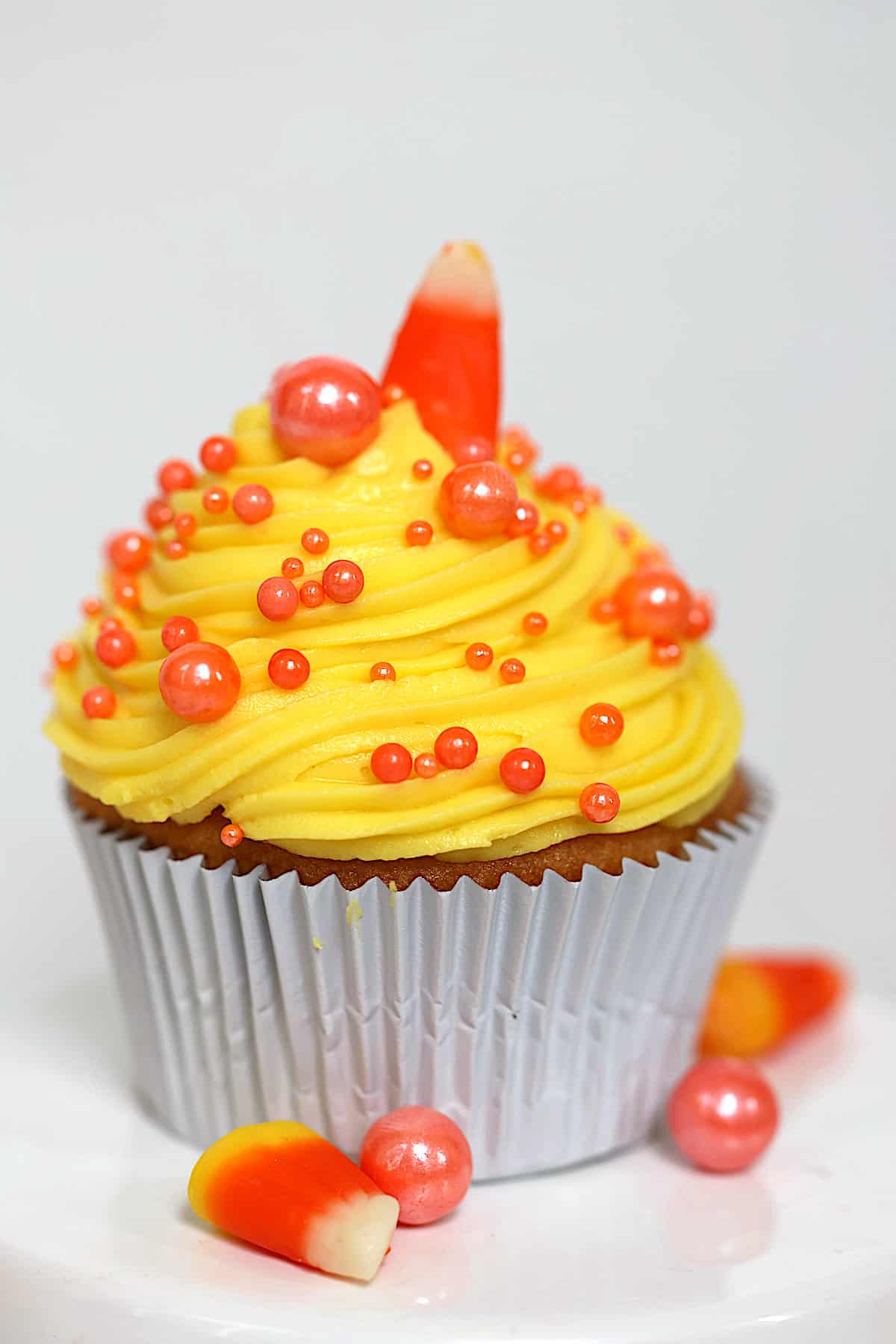 candy corn cupcake on a white stand