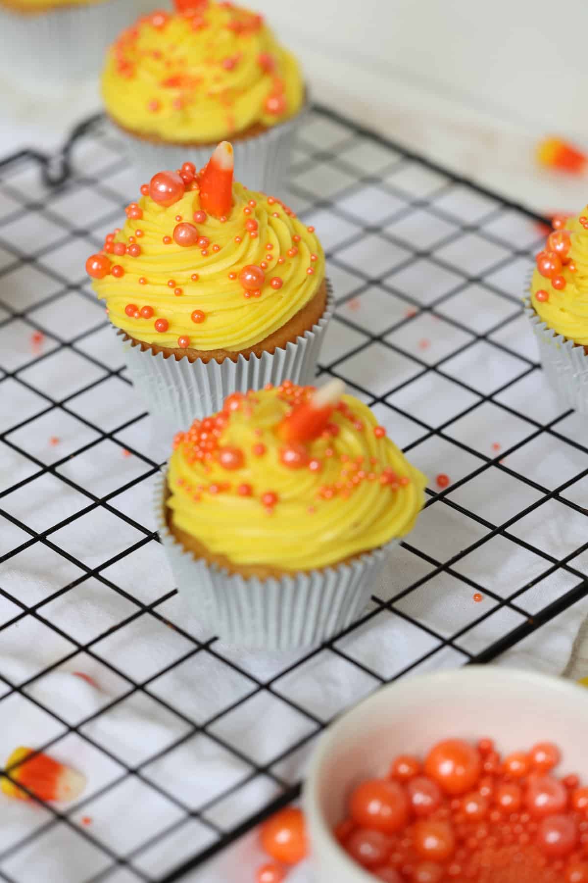 candy corn cupcakes on a baking rack
