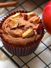 vegan apple muffin in wrapper on a cooling rack
