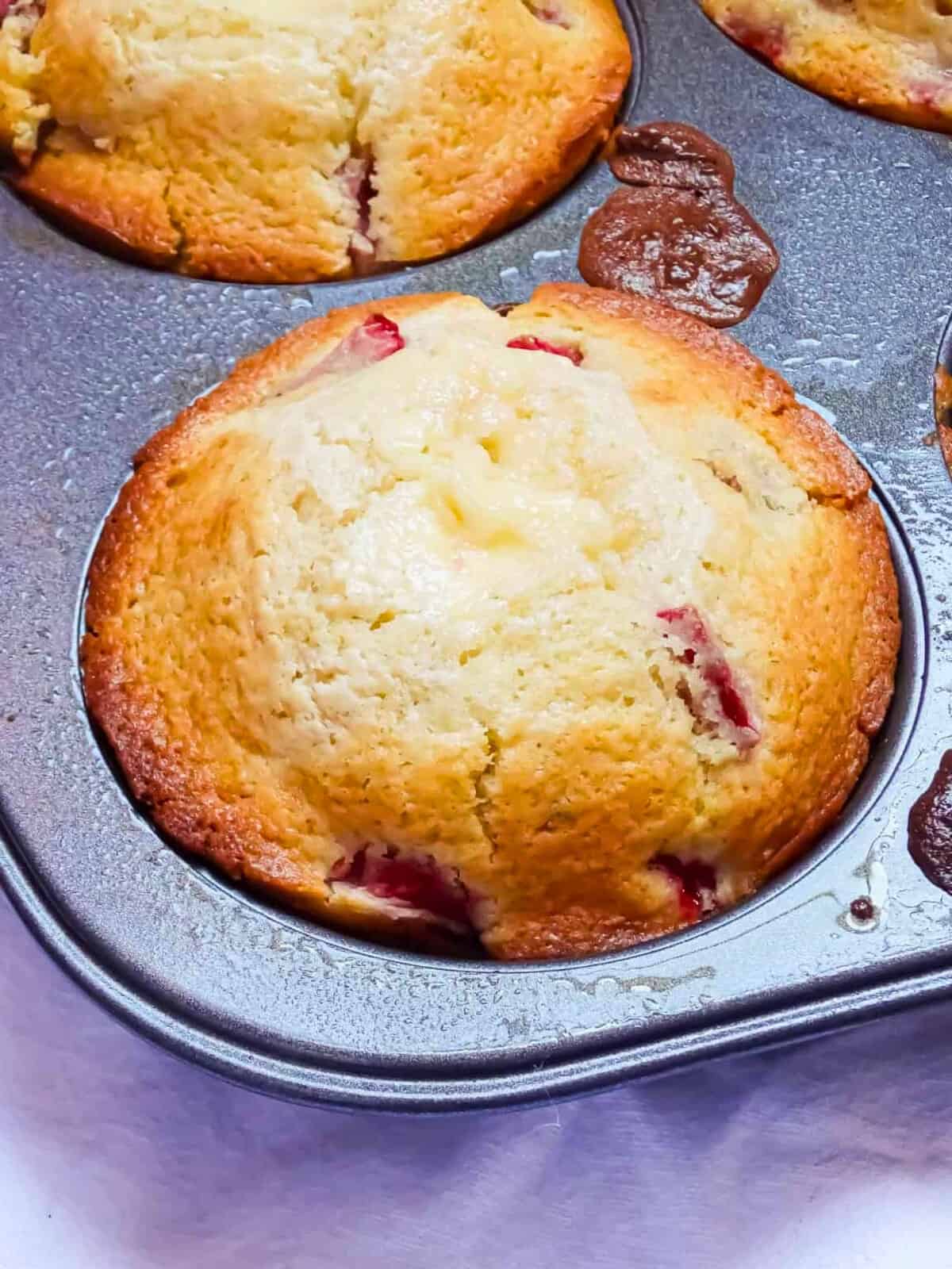 baked strawberry cheesecake muffin in a muffin pan
