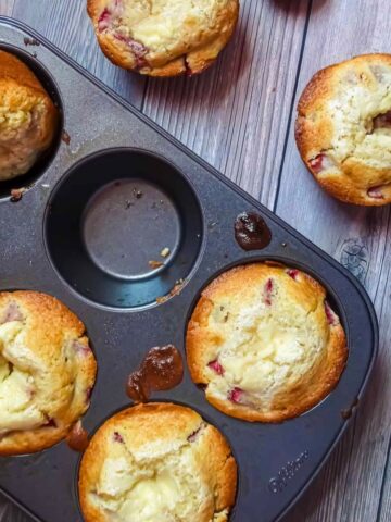 strawberry cream cheese filled muffins in a muffin tin