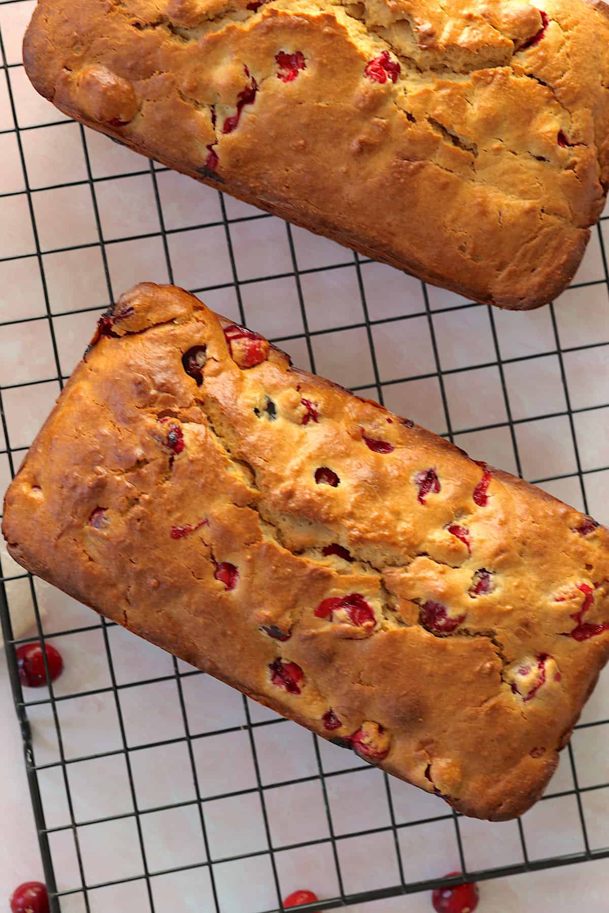 two cranberry loaves on a wire rack