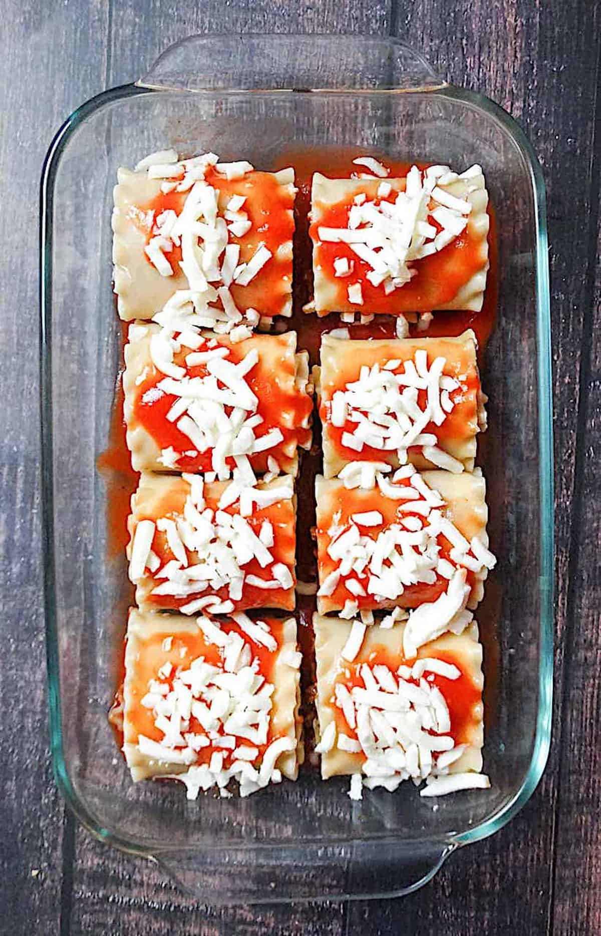 uncooked lasagna roll ups in a casserole dish