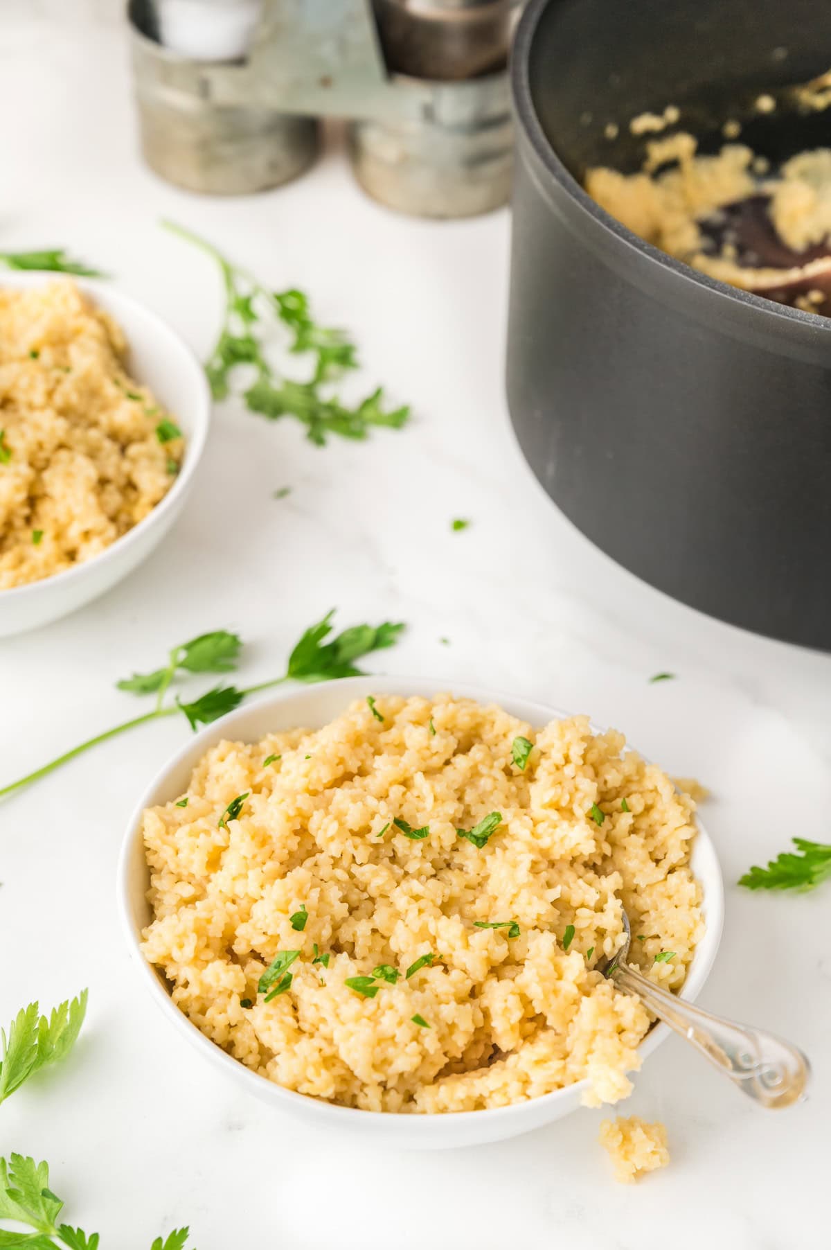pastina in a white bowl topped with fresh herbs