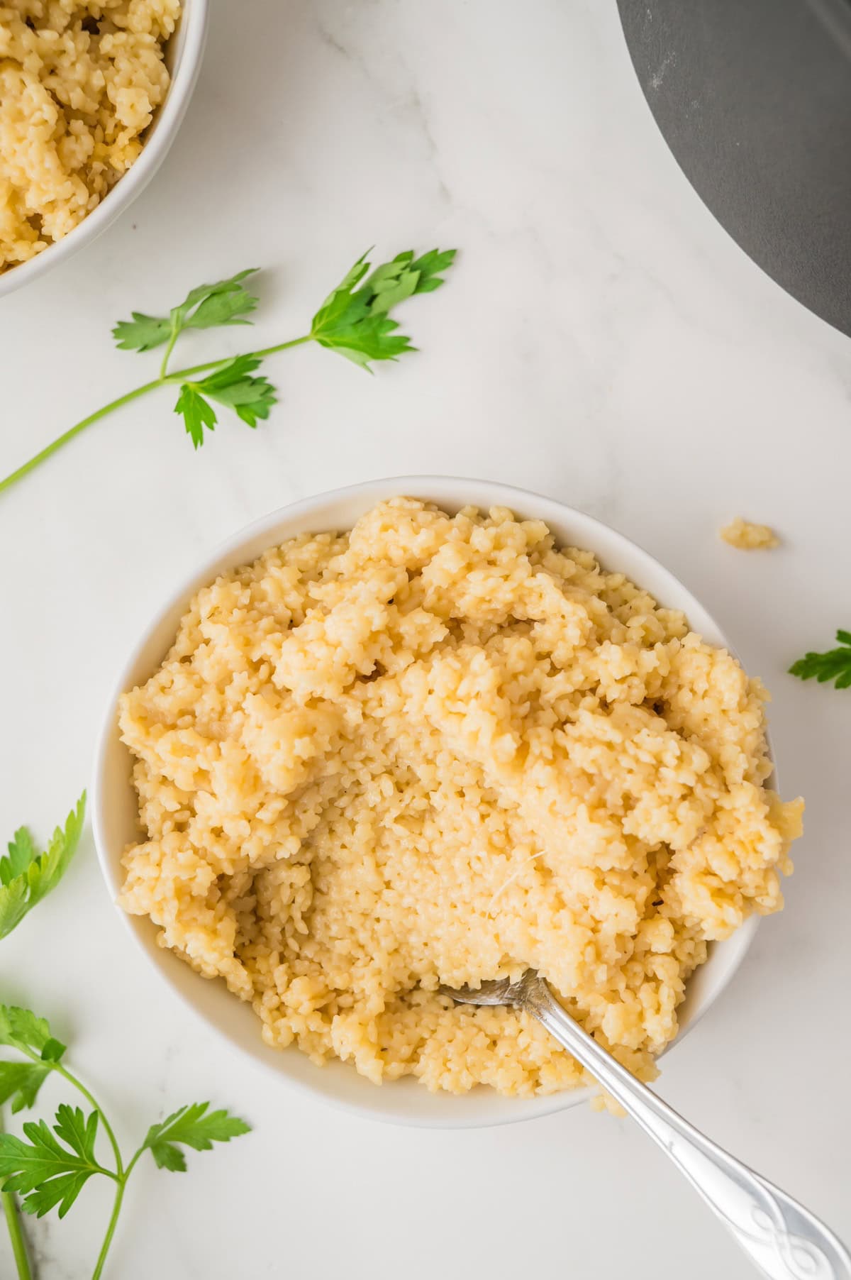 pastina in a white bowl with a scoopful in a spoon