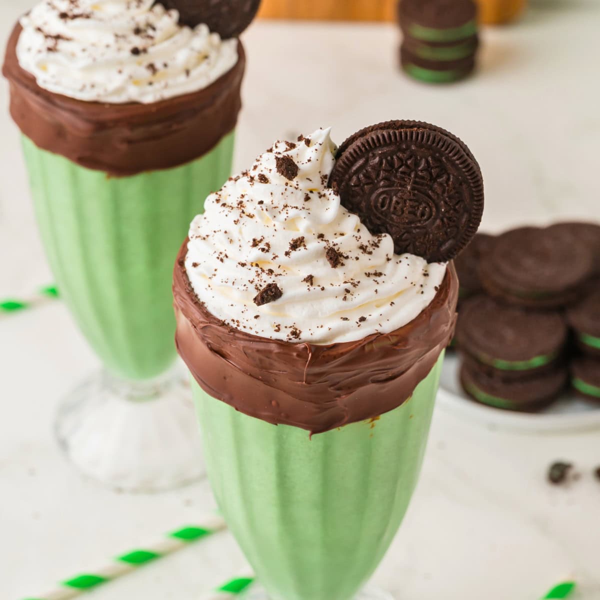 oreo mint milkshake in a milkshake glass lined with chocolate