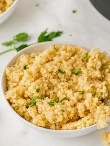 pastina in a white bowl topped with parsley