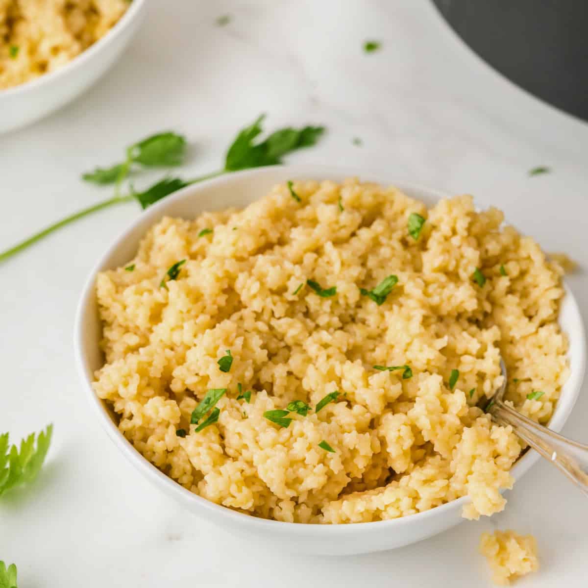 pastina in a white bowl topped with parsley