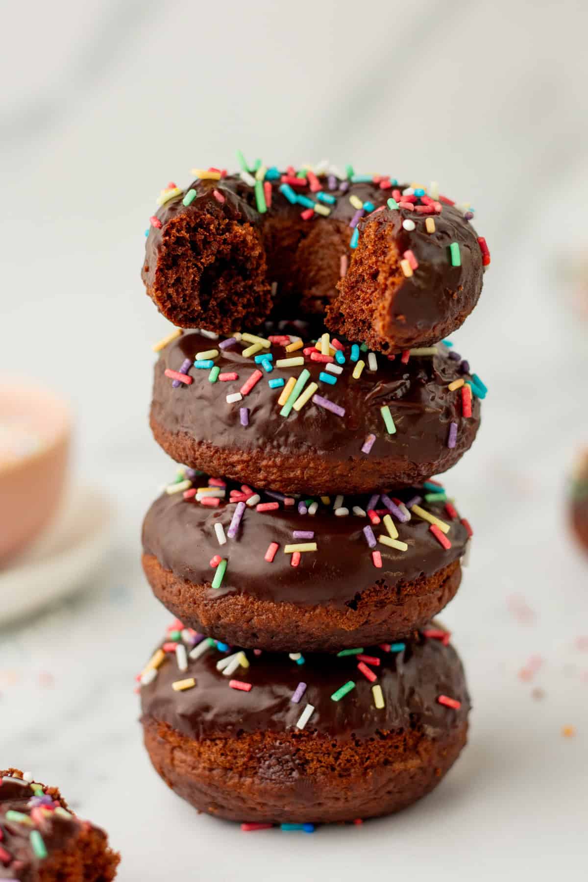 stack of baked chocolate donuts on a white tray