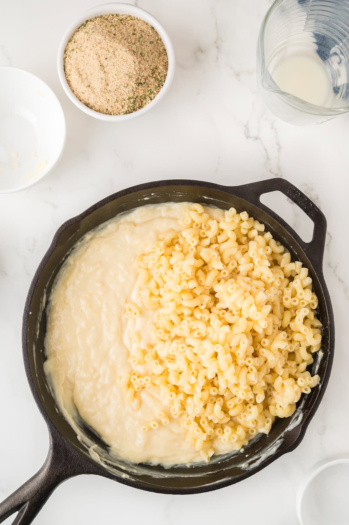 elbow pasta being mixed into the cheese sauce