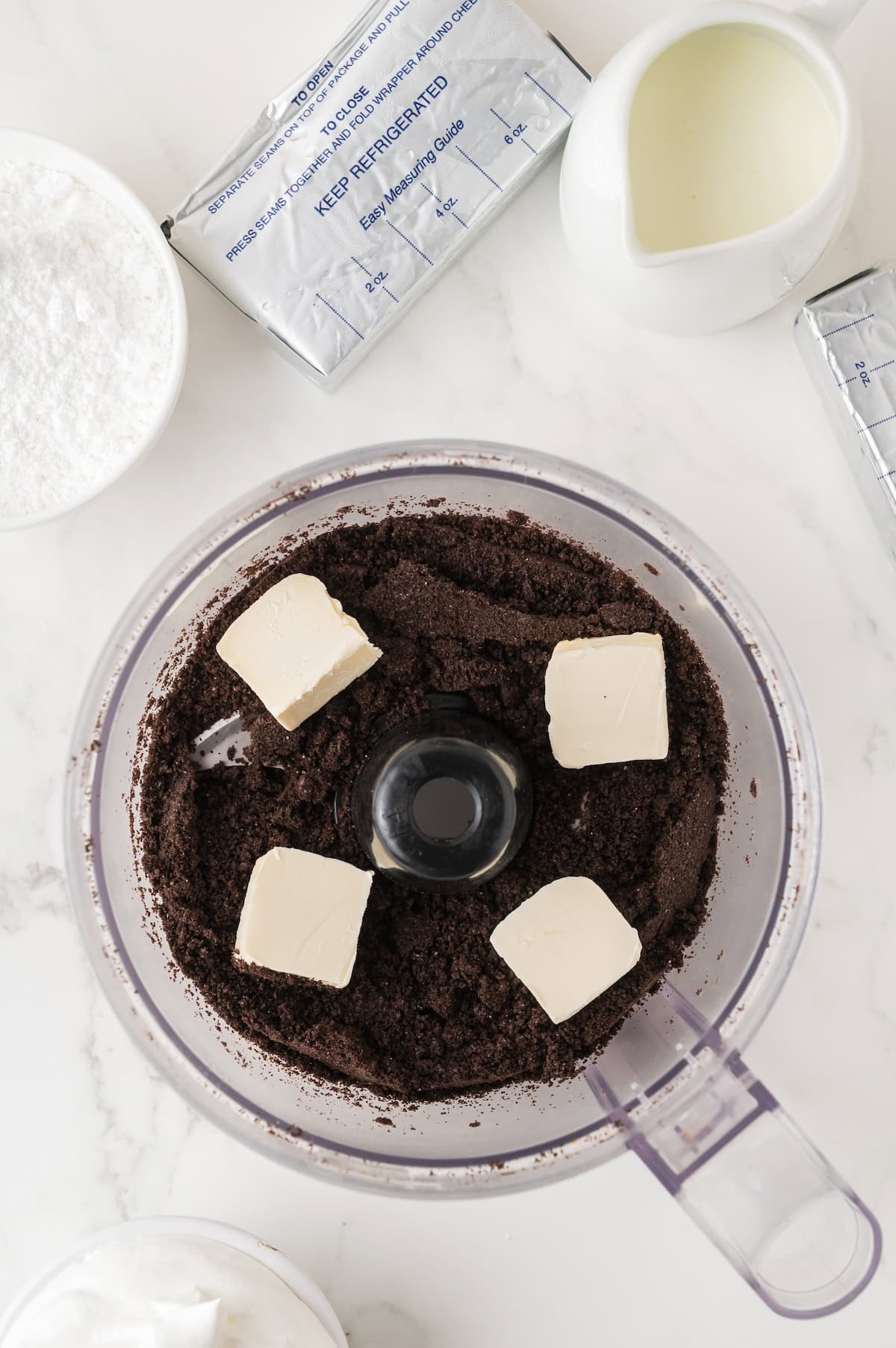 butter and Oreo crumbs in a food processor