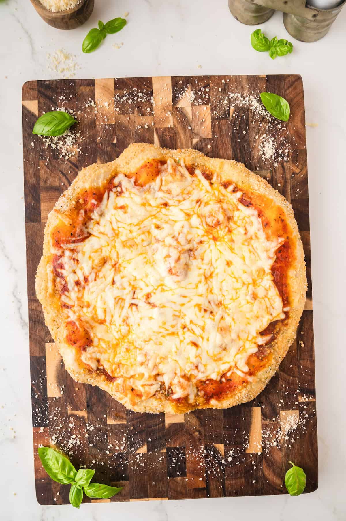 uncut cheese pizza on a cutting board