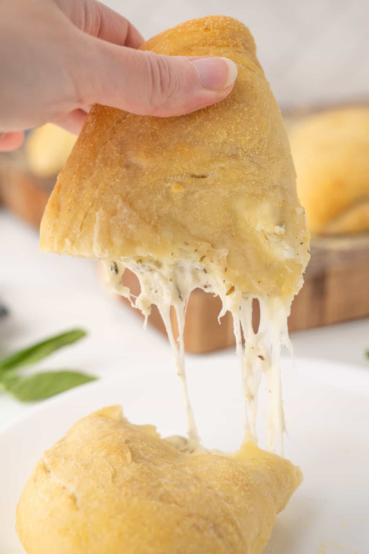 a calzone being bitten apart with cheese hanging