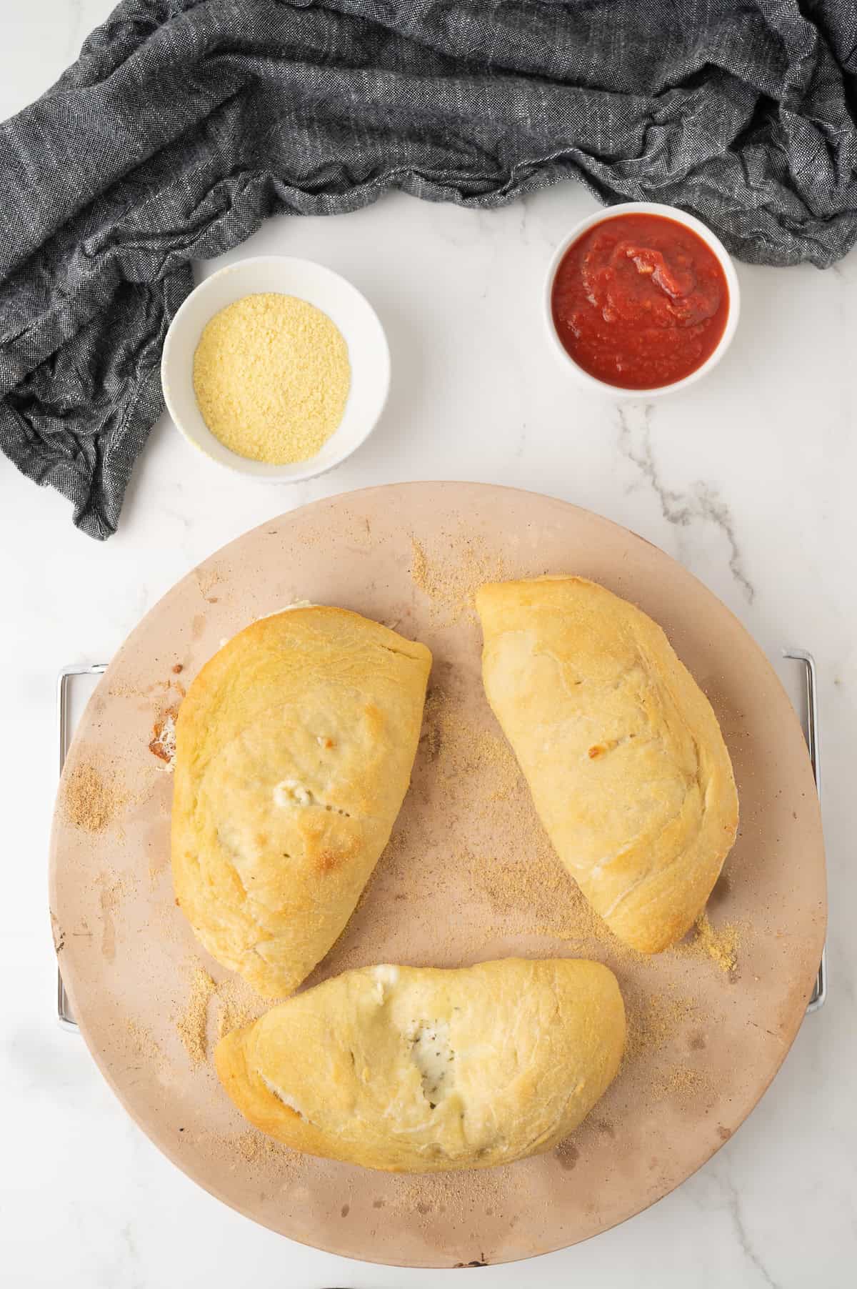 cooked cheese calzones on a pizza stone