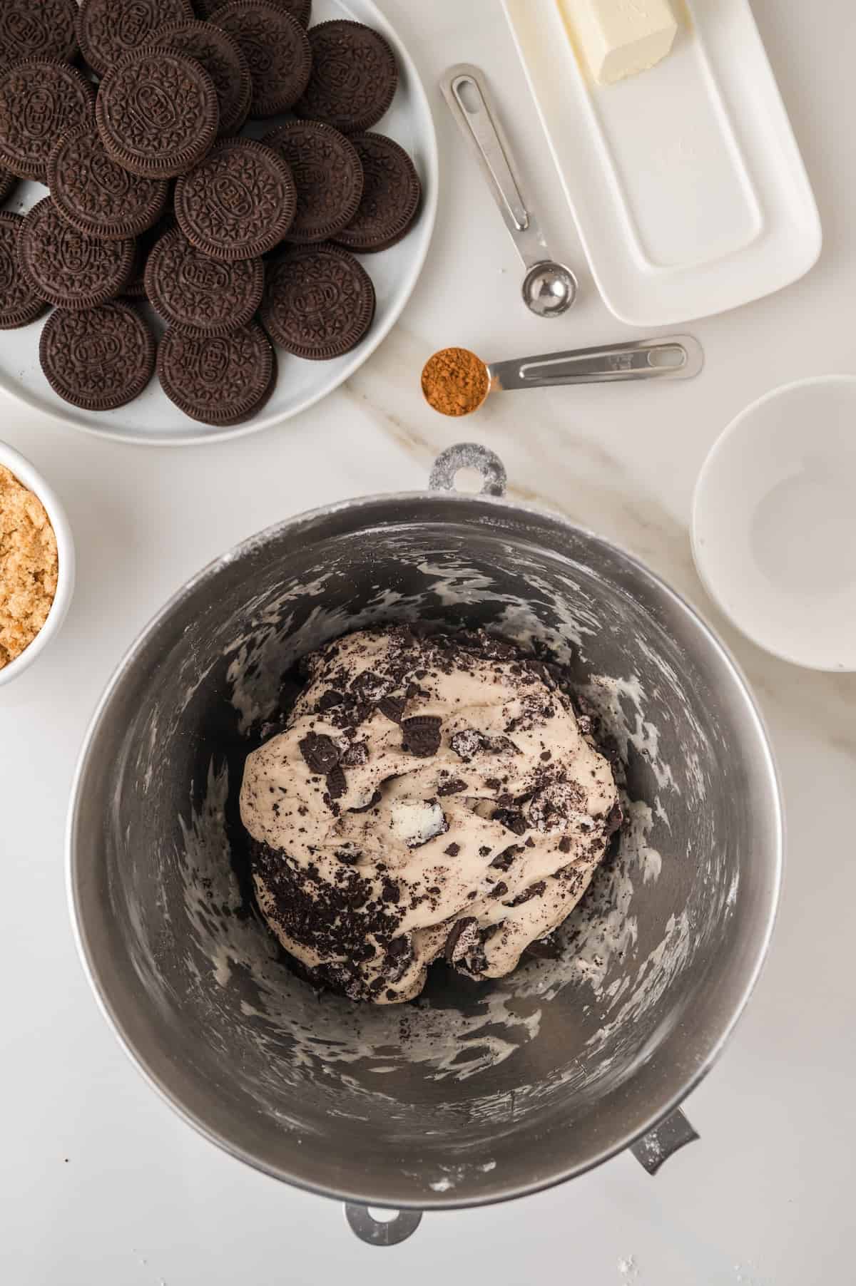 cinnamon roll dough combined with Oreos in a mixing bowl