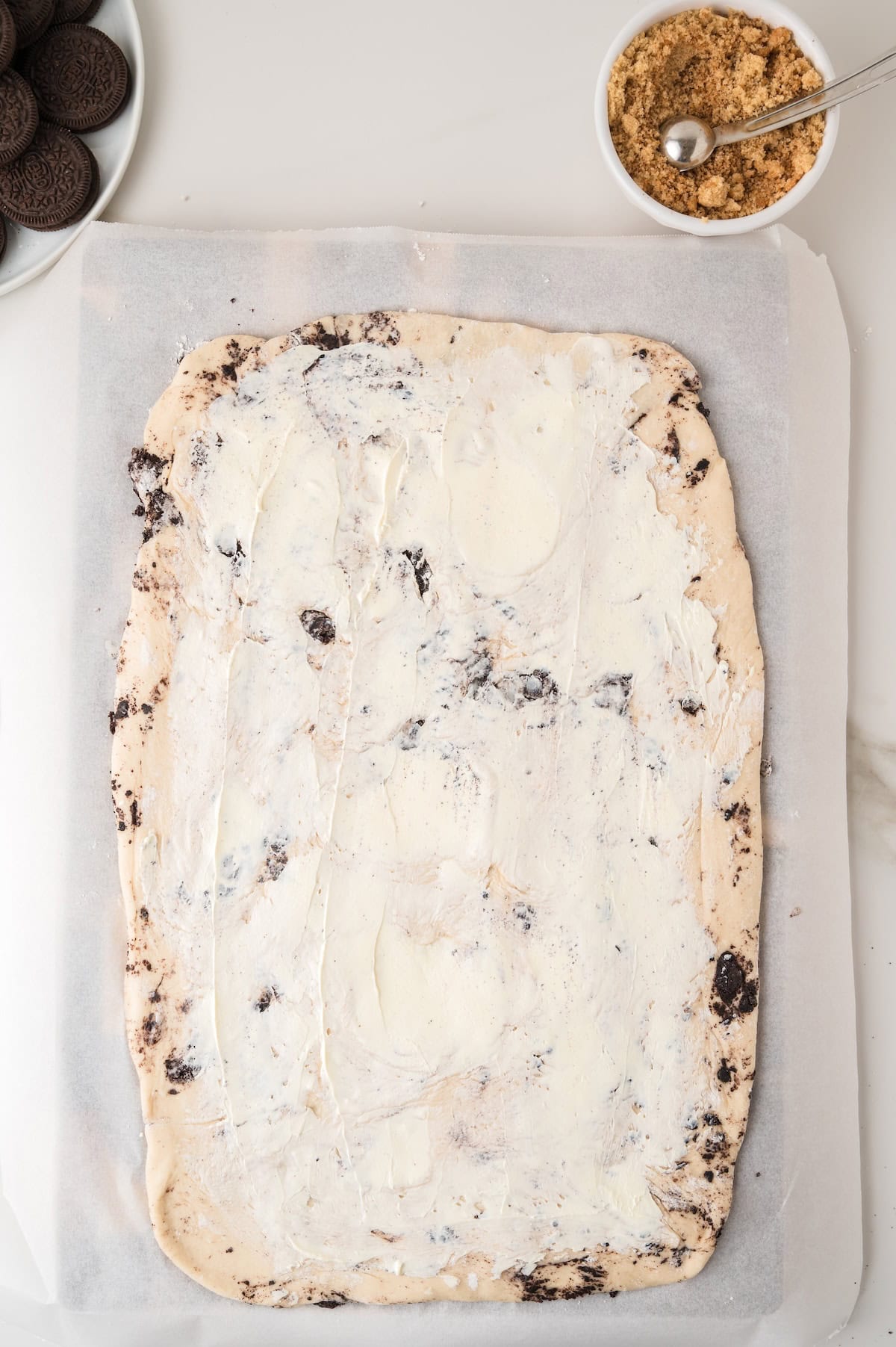 spread cinnamon roll dough in a casserole dish