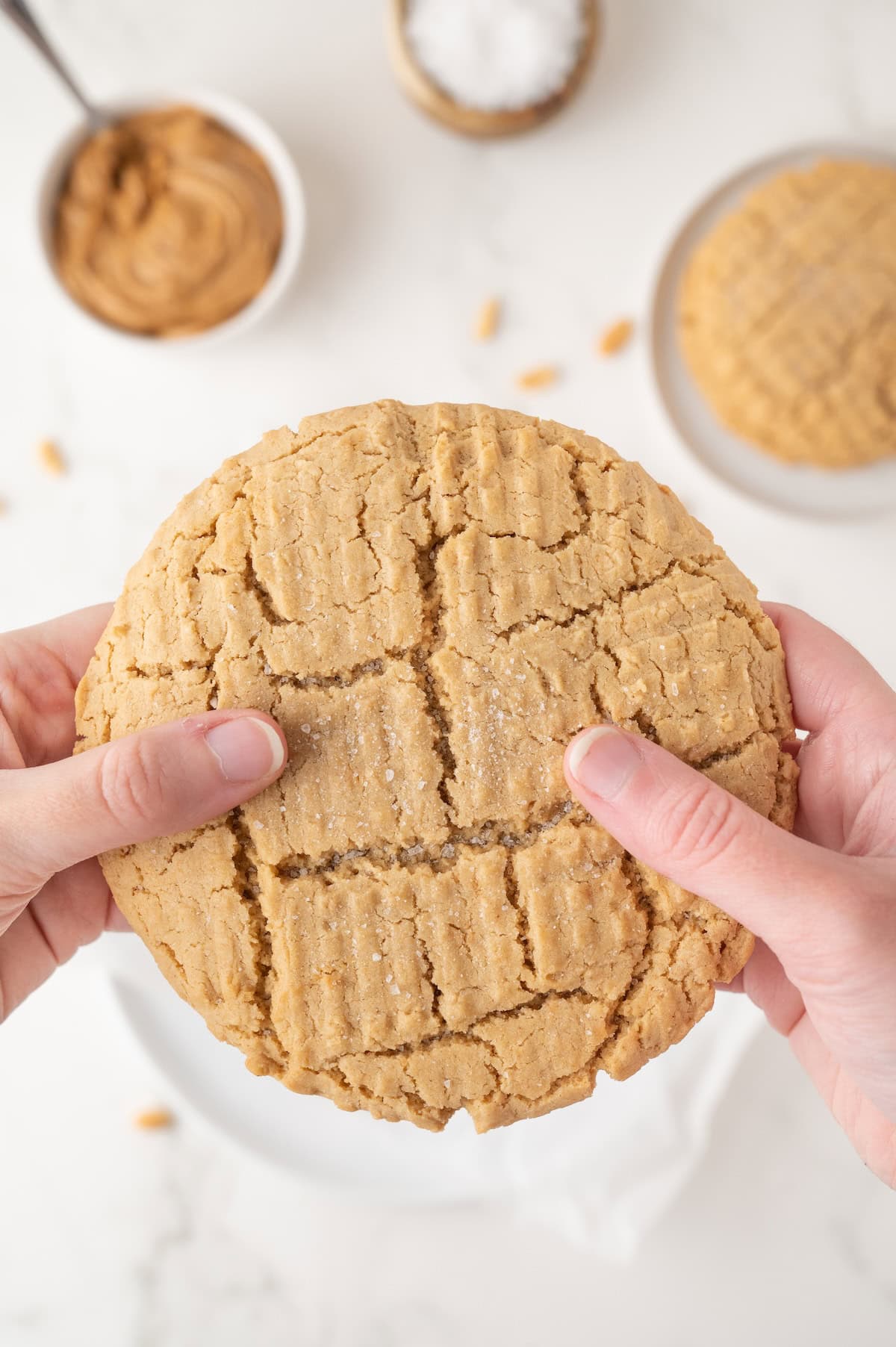 single serving peanut butter cookie being held and torn open