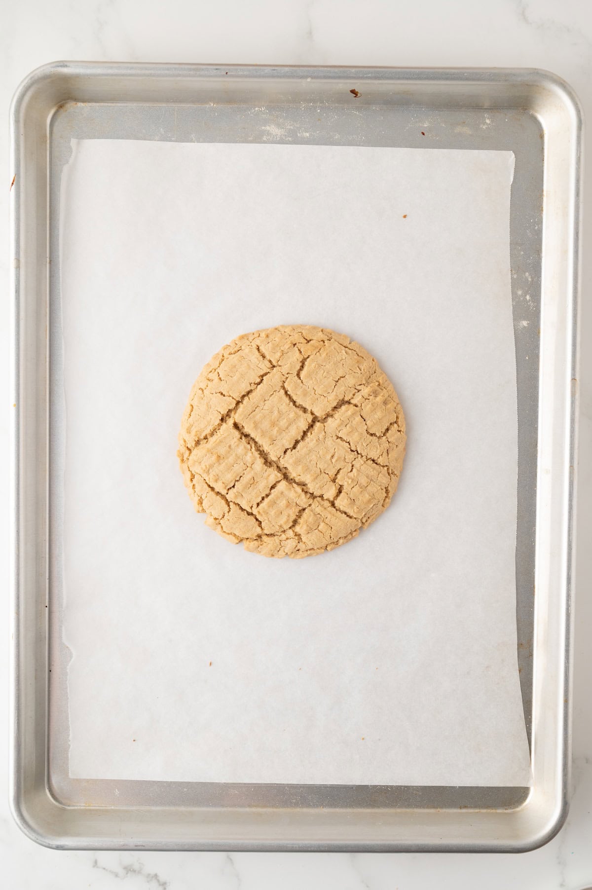 cooked peanut butter cookie on a baking sheet
